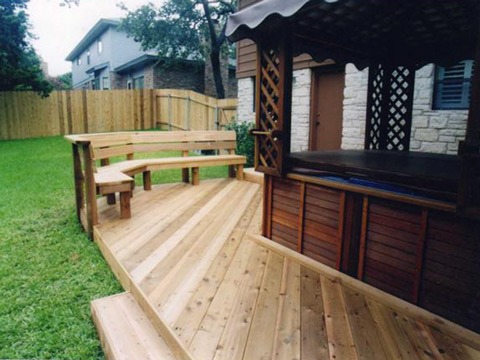 An image of a back deck and porch with bench and jacuzzi.