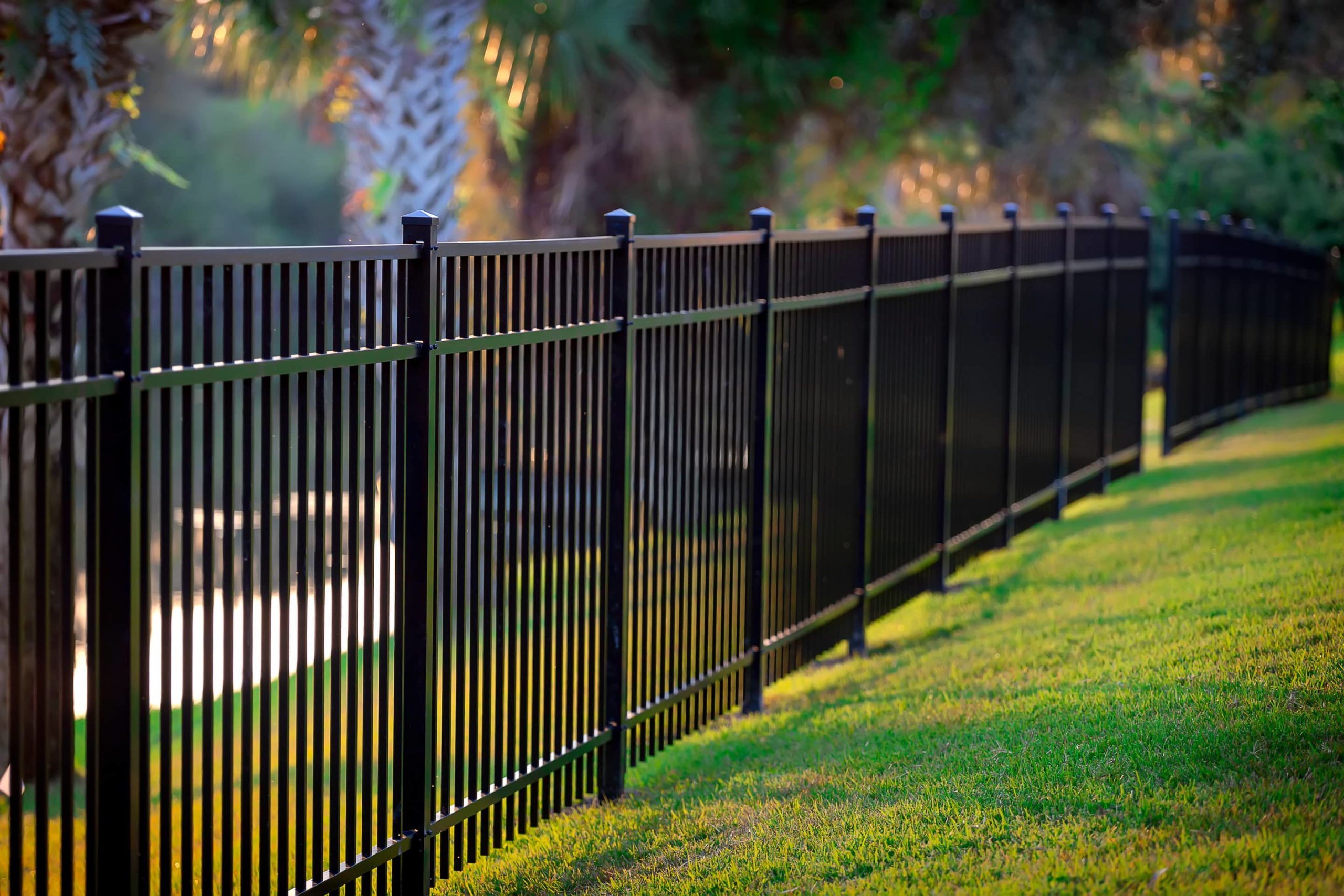An image of a stylish and sturdy metal fence next to a lawn.